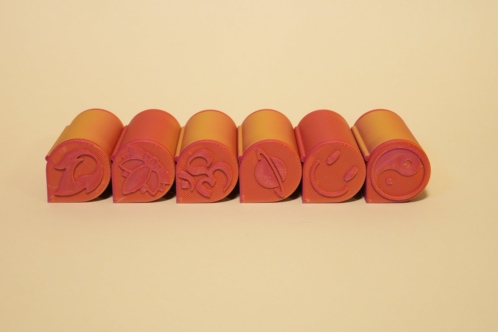 Sechs nibli™ Afterglow-Spender in Rot, Lila und Orange auf cremefarbenem Hintergrund